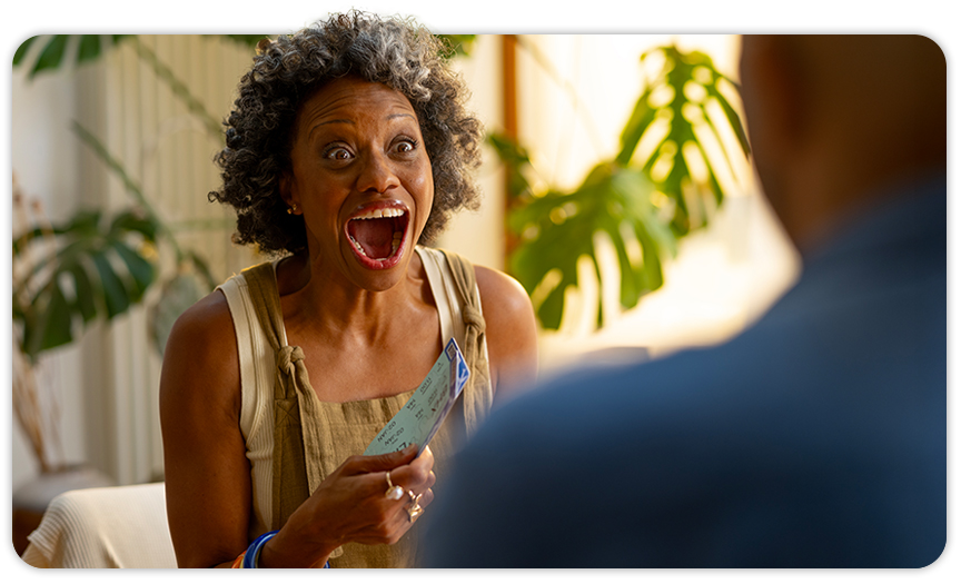 Close up image of a woman holding flight tickets with a surprised face